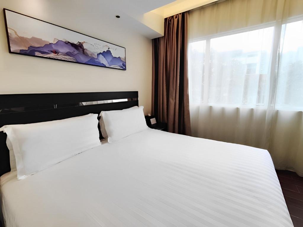 新加坡华星酒店的卧室设有一张白色大床和一扇窗户。