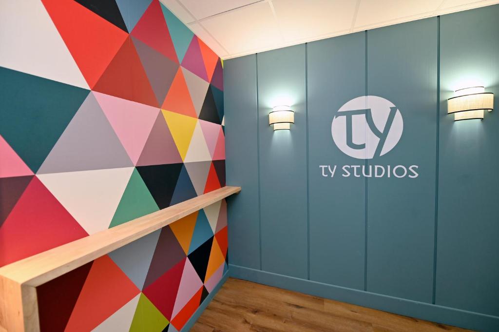 布雷斯特TY STUDIOS Hyper Centre Ville的墙上有电视工作室标志的彩色墙壁