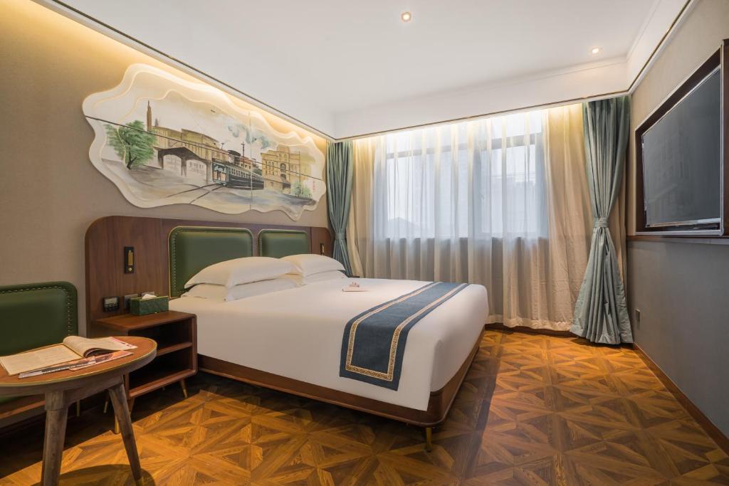 上海时光漫步S酒店（上海五角场店）的一间卧室配有一张床、一张桌子和一台电视