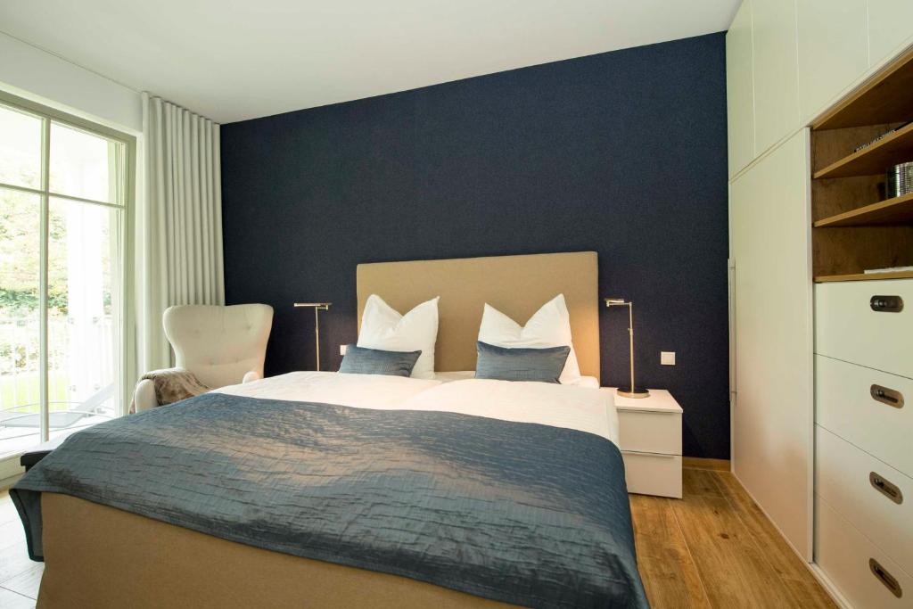 奥斯特巴德·哥伦Villa Pauline Whg. 01 mit Balkon的一间卧室配有一张带蓝色墙壁的大床