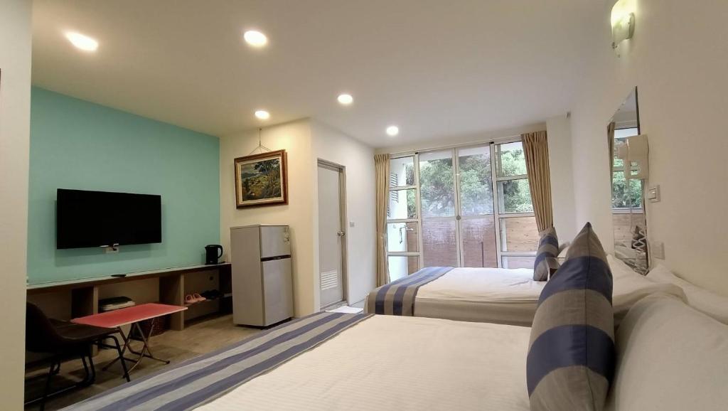 鹿谷乡溪头天品民宿的酒店客房设有两张床和电视。