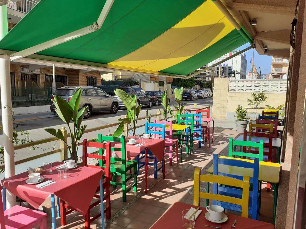 甘迪亚Hotel Clibomar Jamaica的街上一张桌子和五颜六色的椅子