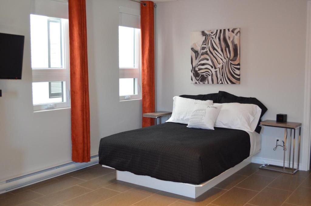 鲁安Le Chic-Urbain的一间卧室设有一张床和两个窗户。