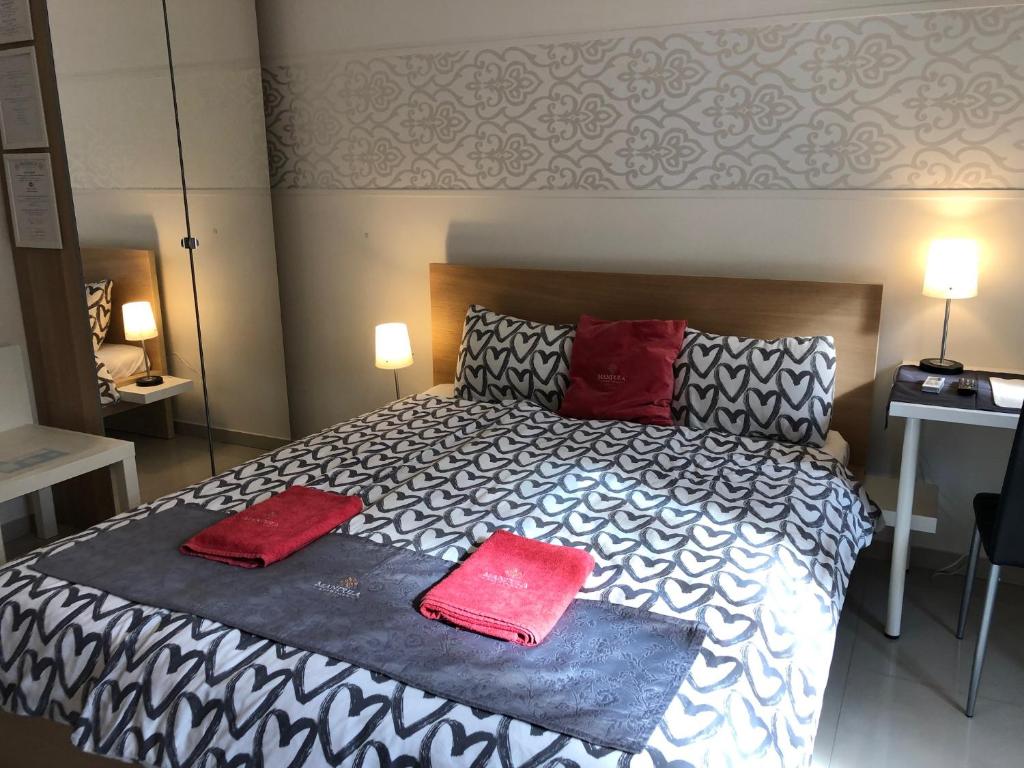采格莱德Mandula Apartman的一间卧室配有一张带两个红色枕头的床