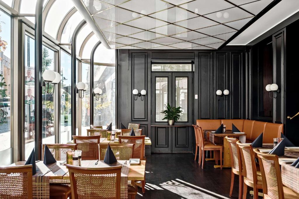 海宁艾德贝斯特韦斯特优质酒店的餐厅设有木桌、椅子和窗户。