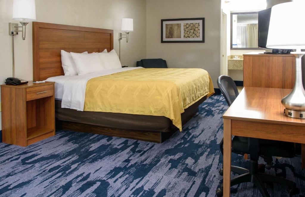 刘易斯堡Quality Inn的配有一张床和一张书桌的酒店客房