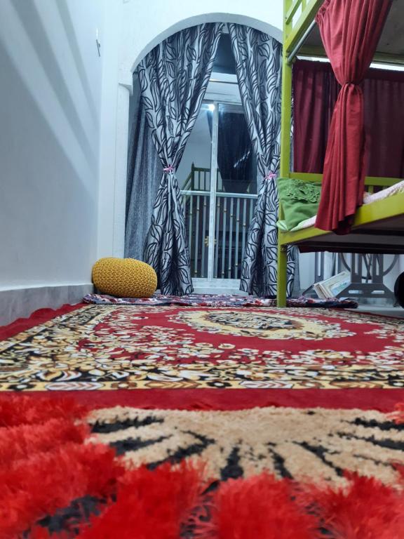 斋浦尔Ali Baba Hostel的一间地板上铺有地毯的房间和窗户