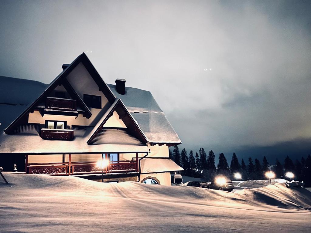 布科维纳-塔钱斯卡Harmatówka Concept Mountain的雪中的房子,灯亮