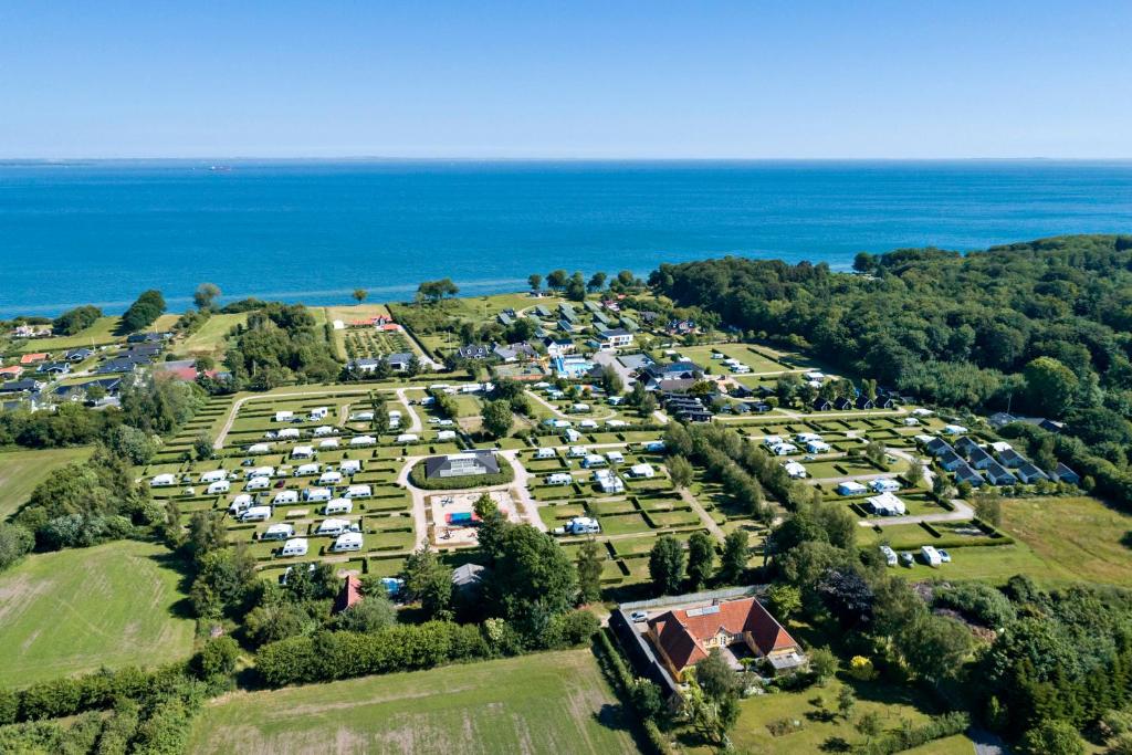 BåringFirst Camp Skovlund Camping & Cottages的享有毗邻大海的停车场的空中景致