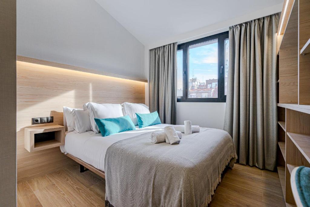 马德里Feelathome Ventas Suites的一间卧室配有一张带蓝色枕头的大床