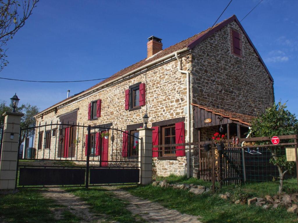 Saint-Maurice-près-PionsatPretty gîte with private pool的一座带红色百叶窗和门的老砖屋