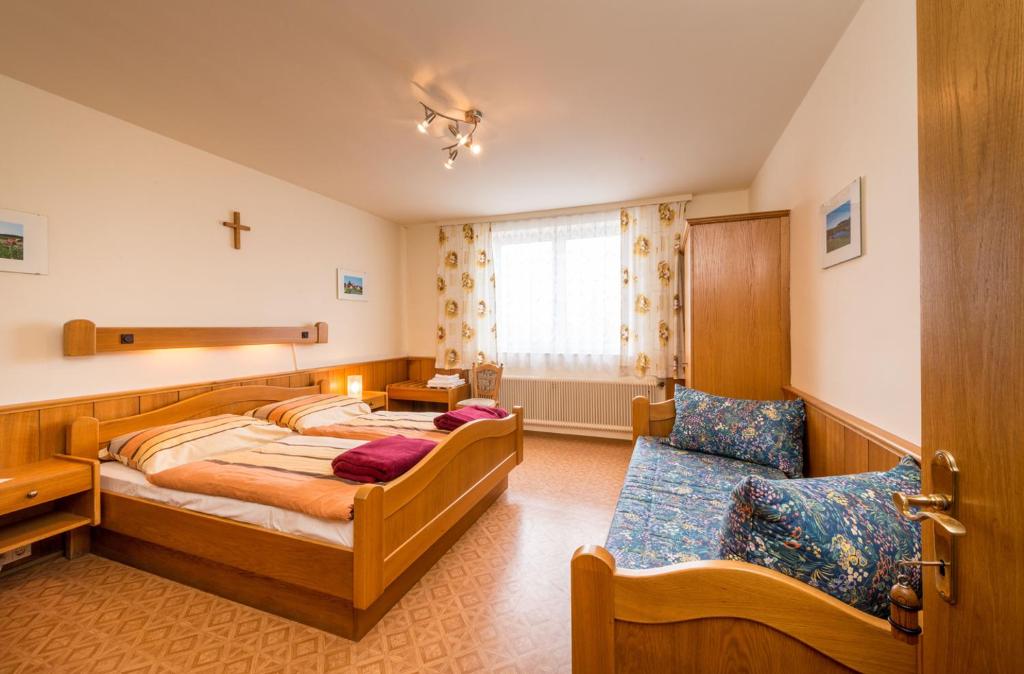 GrafenschlagGasthaus Bauer的卧室配有两张床,墙上有一个十字架