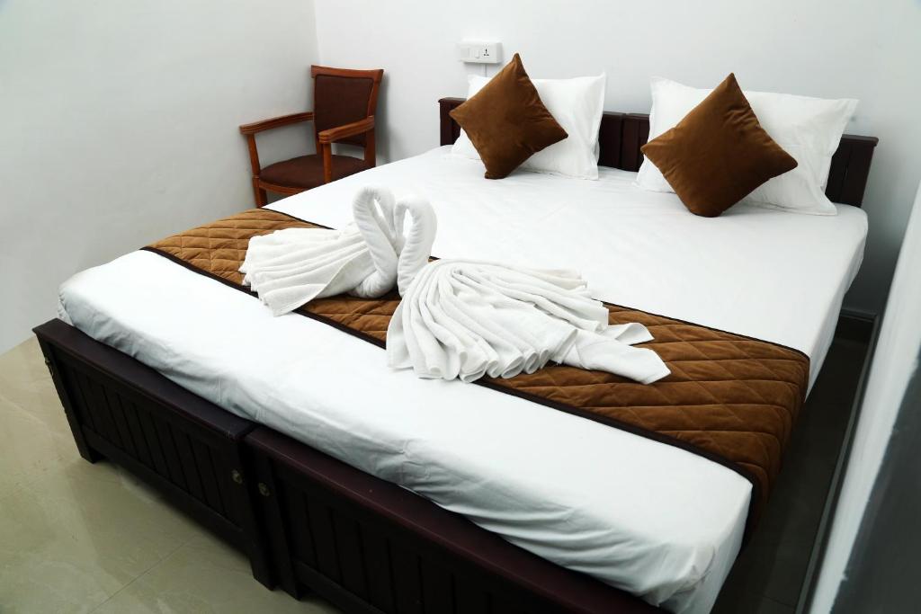 科钦AWA Residency的配有2张床的带白色床单和枕头的客房