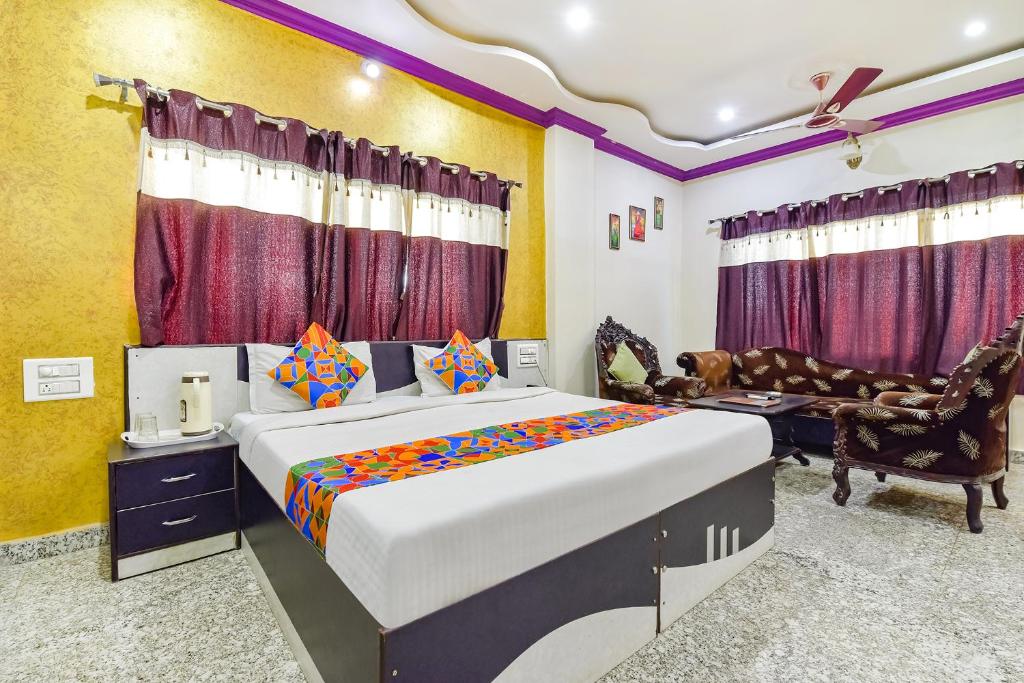 乌代浦FabExpress Relax Inn I, Udaipur的一间卧室配有一张特大号床和一张沙发
