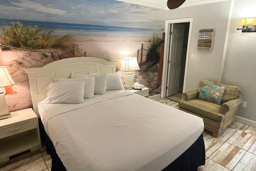 格尔夫海岸Beachview 208的卧室配有一张白色大床和一把椅子