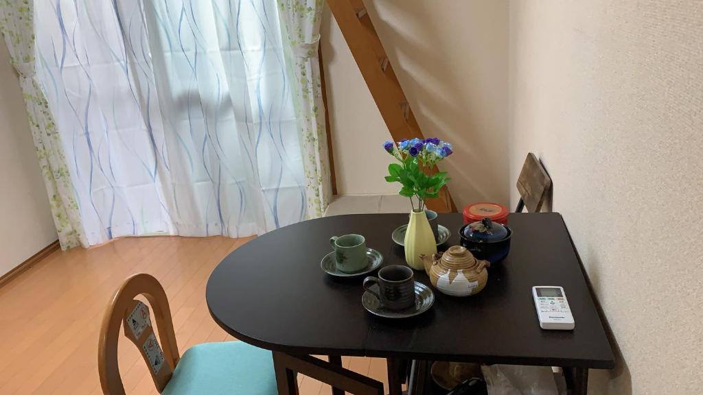 埼玉市大宮溫馨小屋的一张黑色桌子,上面有花瓶