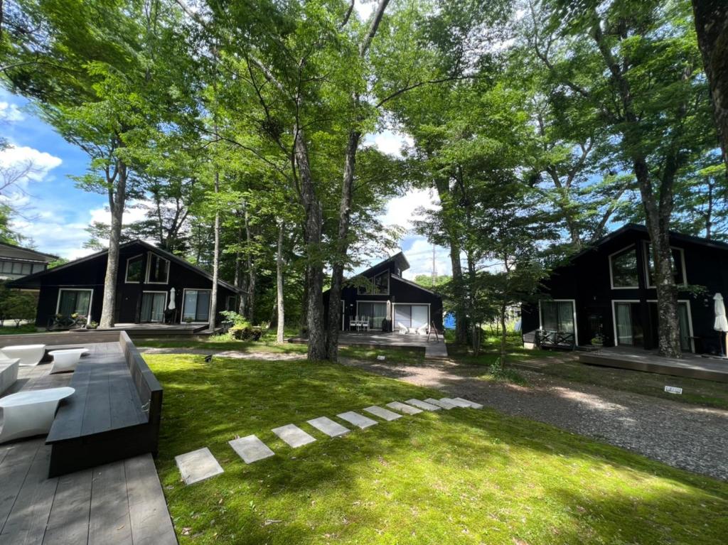 山中湖村Forest Villa Yamanakako的草上长凳的后院
