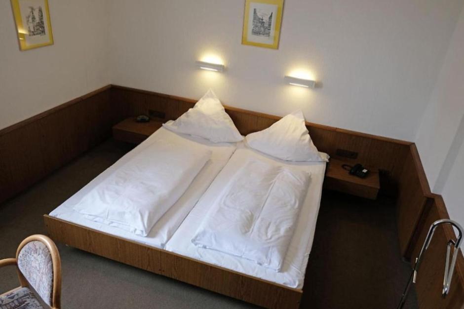 布伦瑞克Lessinghof的一间卧室配有带白色床单和枕头的床。