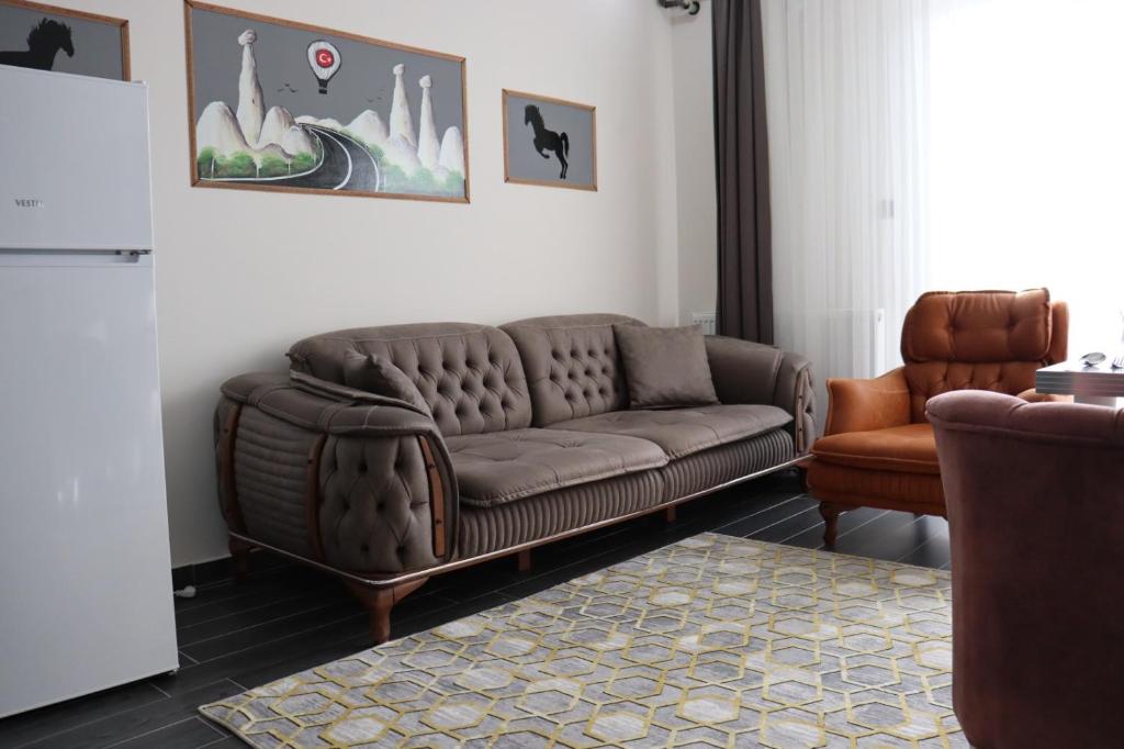 内夫谢希尔Loft Palace Suit的客厅配有棕色沙发和椅子