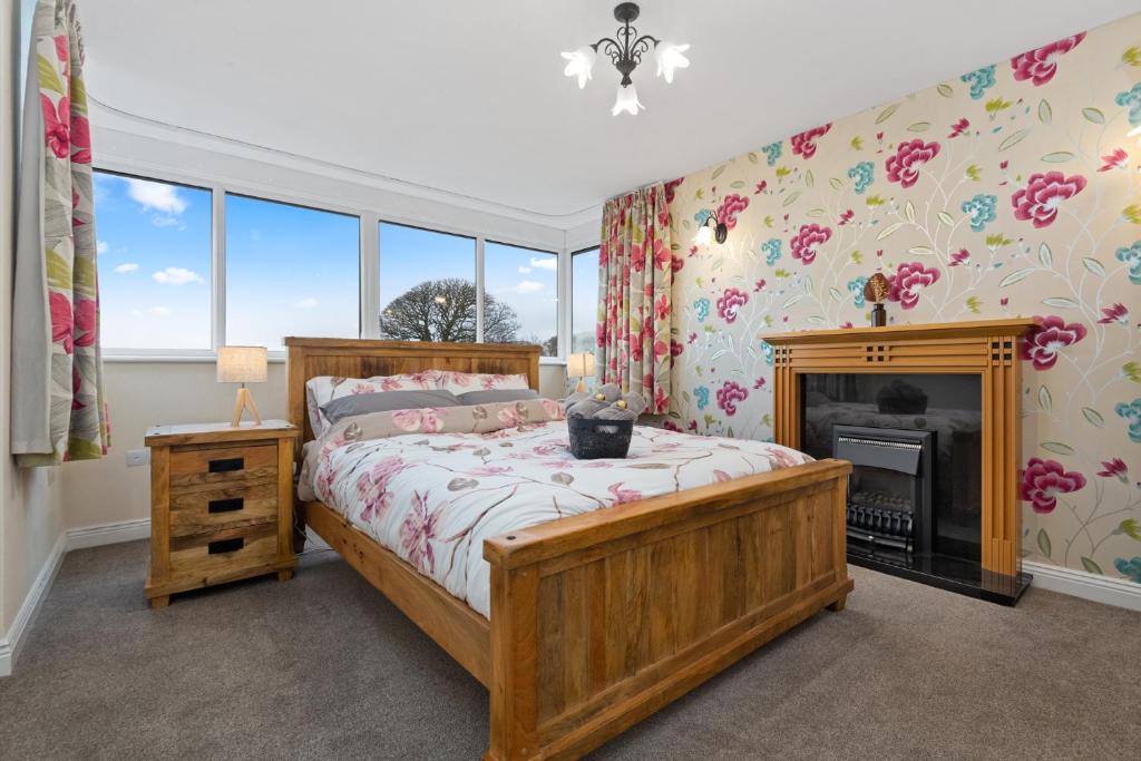 DistingtonComfy Cumbrian Stay的一间卧室设有一张木床和一个壁炉
