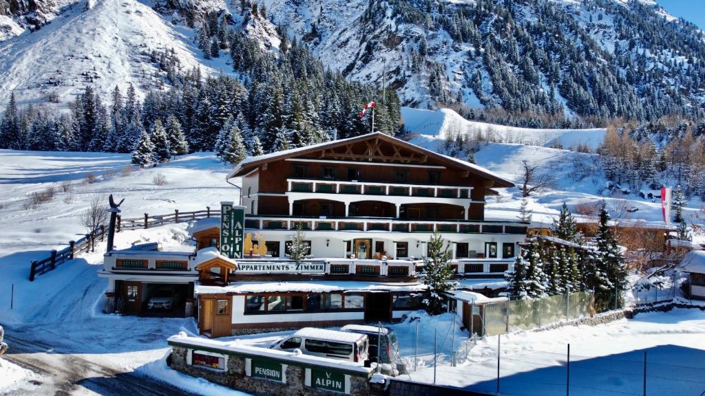 曼达芬Pension Alpin的山底下雪中的酒店