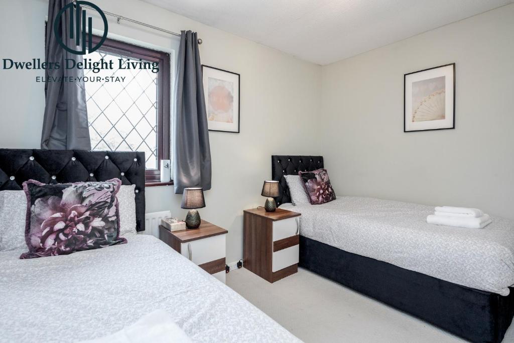 伍德福德格林Dwellers Delight Living Ltd Serviced accommodation 2 Bed House, free Wifi & Parking, Prime Location London, Woodford的一间卧室设有两张床和窗户。