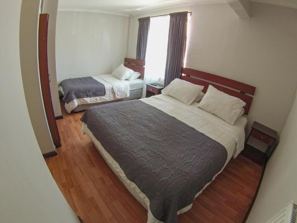 康塞普西翁德里奥旅馆的一间小卧室,配有两张床和窗户