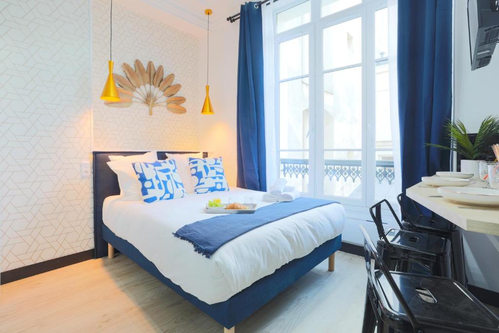 巴黎Apartments WS Hôtel de Ville - Beaubourg的一间卧室配有一张带蓝色和白色枕头的床