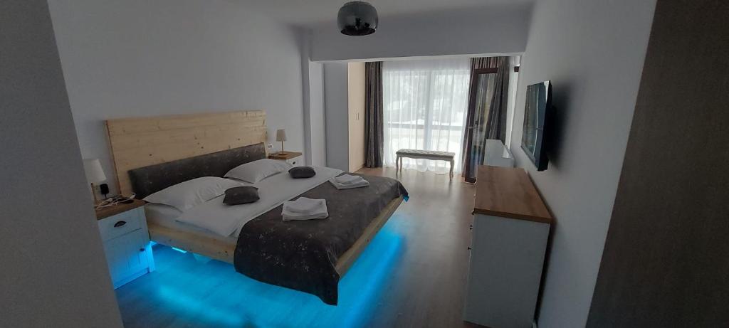 普雷代亚尔HAPPY SUMMER -Predeal的一间卧室配有一张带蓝色灯光的大床
