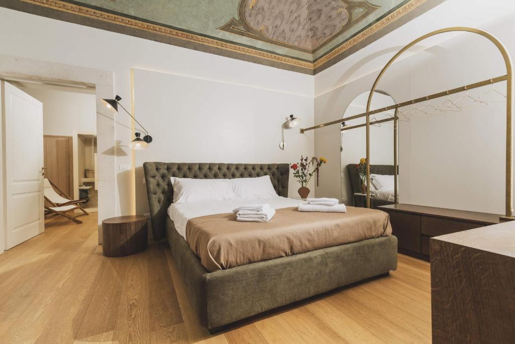 拉奎拉Casa Horti Suites的卧室配有一张床,墙上设有镜子
