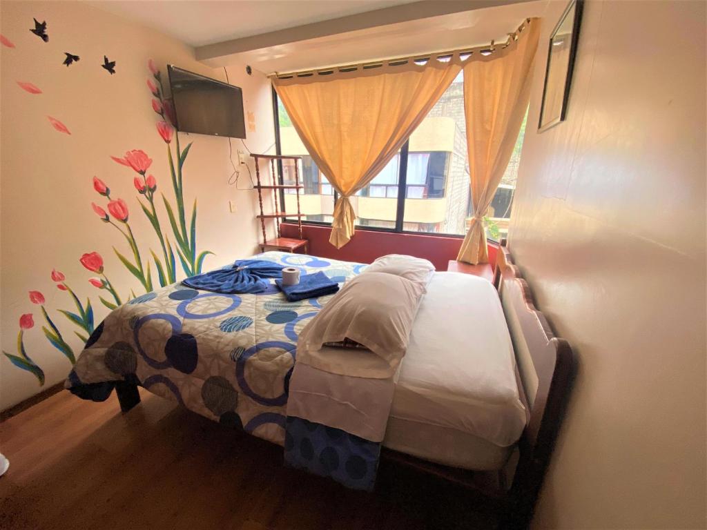 巴尼奥斯Hostal los Andes的一间带床的卧室,位于带窗户的房间内