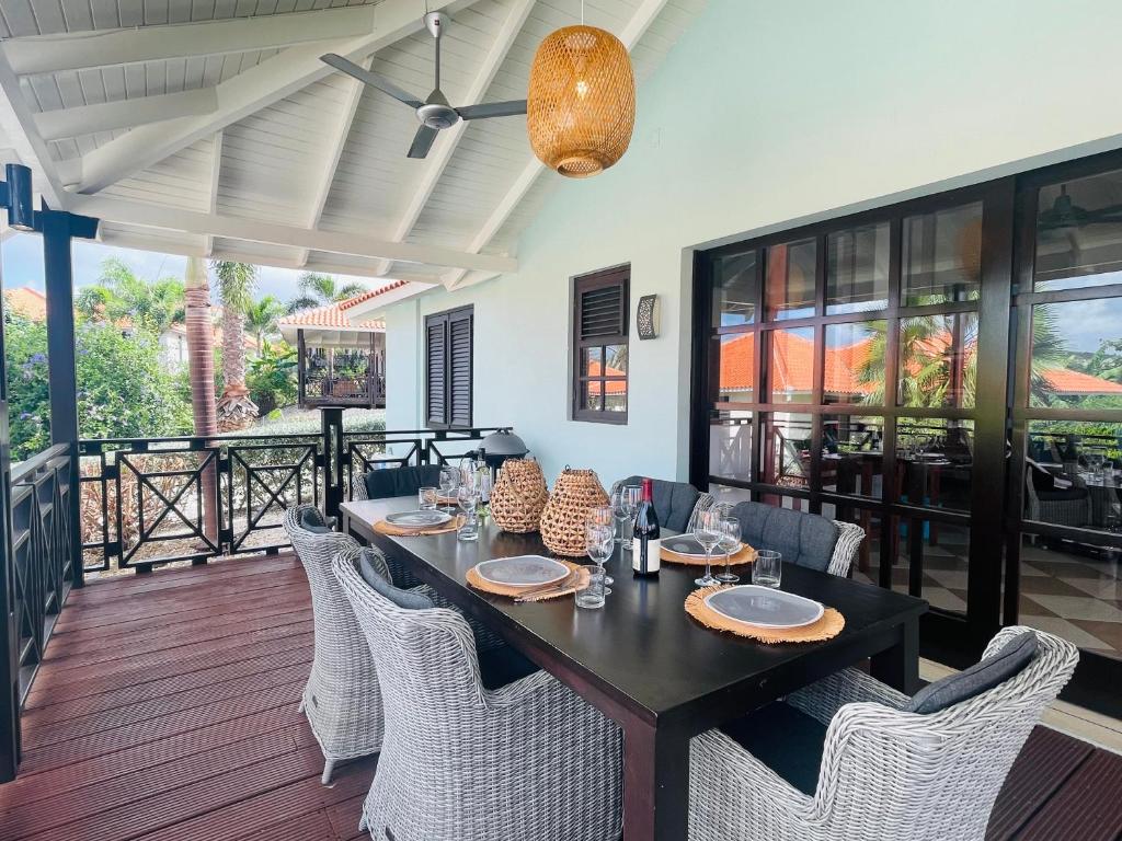 Dorp Sint MichielTip! Blue Bay Beachvilla 12 - Blue Bay Resort的一间用餐室,配有黑色的桌子和椅子