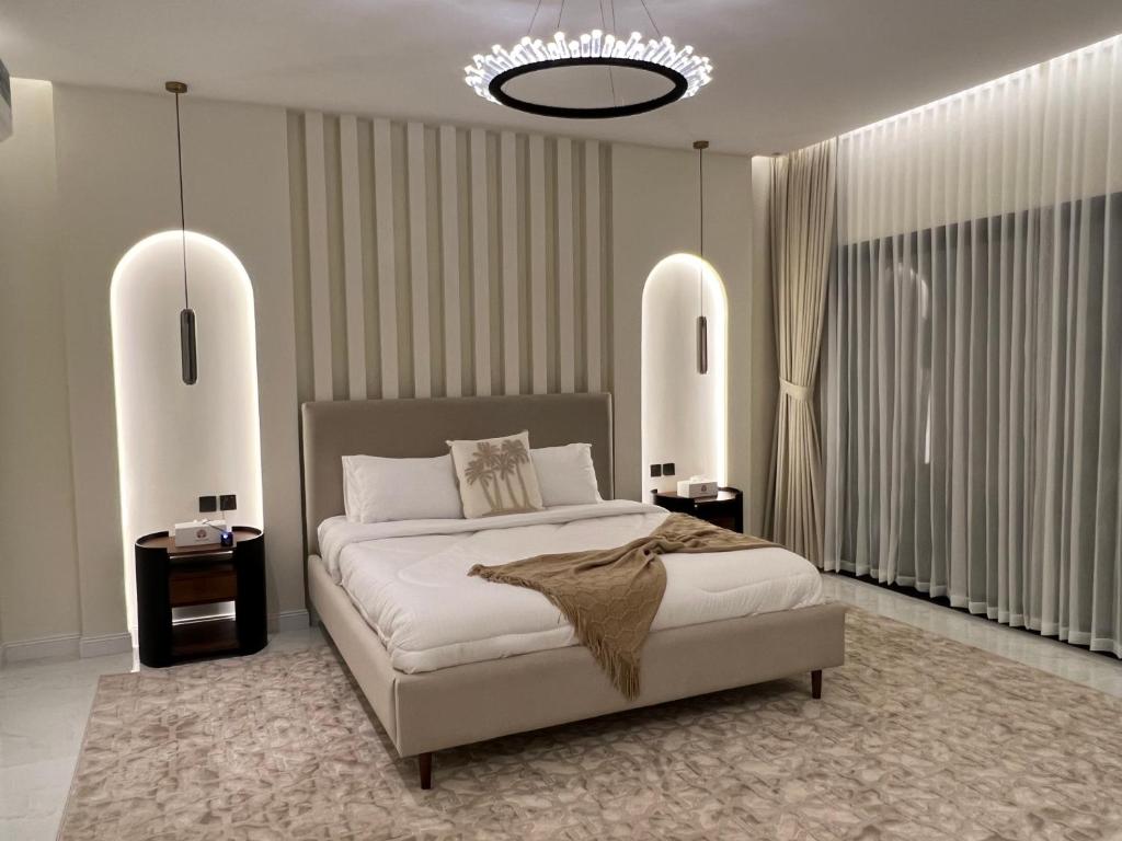 八田Quiet House villa的一间卧室配有一张大床和一个吊灯。