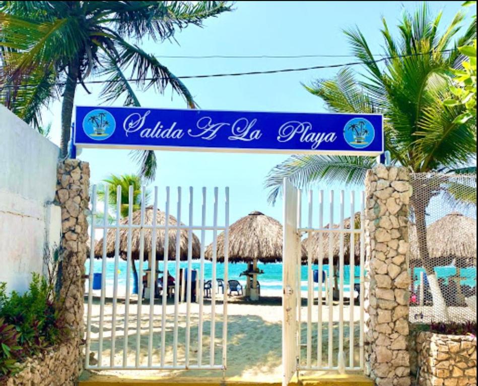Puerto ViejoCondominio Victoria Real - Apartamento 202的海滩的大门,上面有蓝色的标志