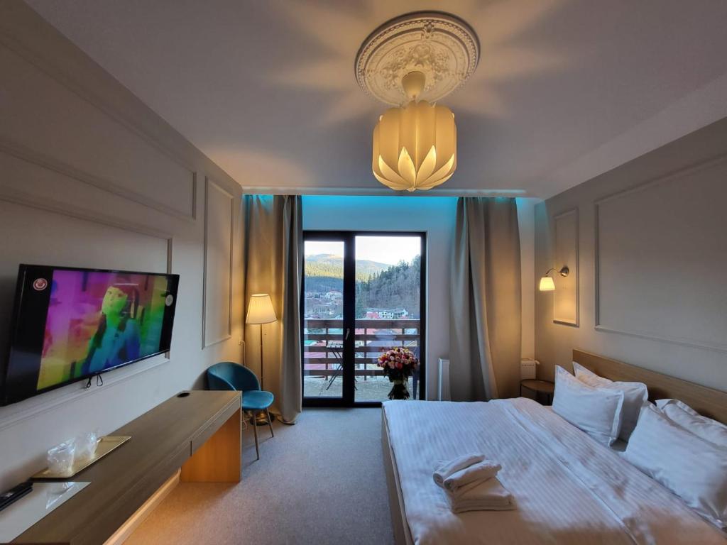 布什泰尼Vila PANORAMIC Busteni的酒店客房设有一张大床和一台电视。
