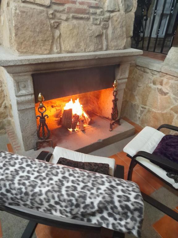 SotoserranoHotel Rural Sierra de Francia的石头壁炉前配有桌椅