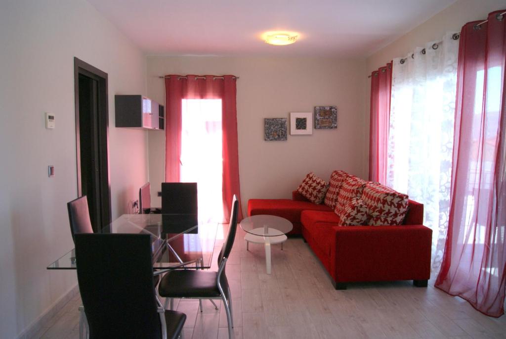 BeniarbeigPomera I - BTB的客厅配有红色的沙发和玻璃桌