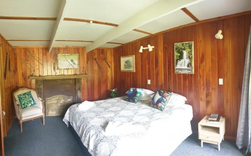 WaimihaBlackfern Lodge的卧室配有木墙内的一张床