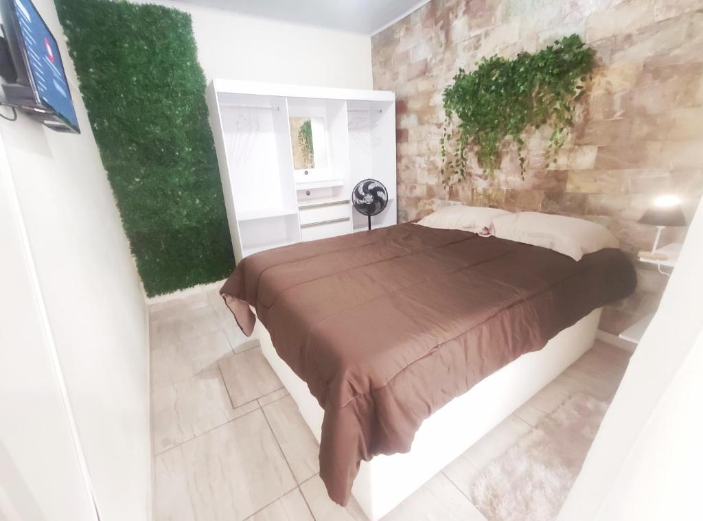 贝洛奥里藏特Kitnet Lua - Mobiliada的一间卧室设有一张大床和石墙