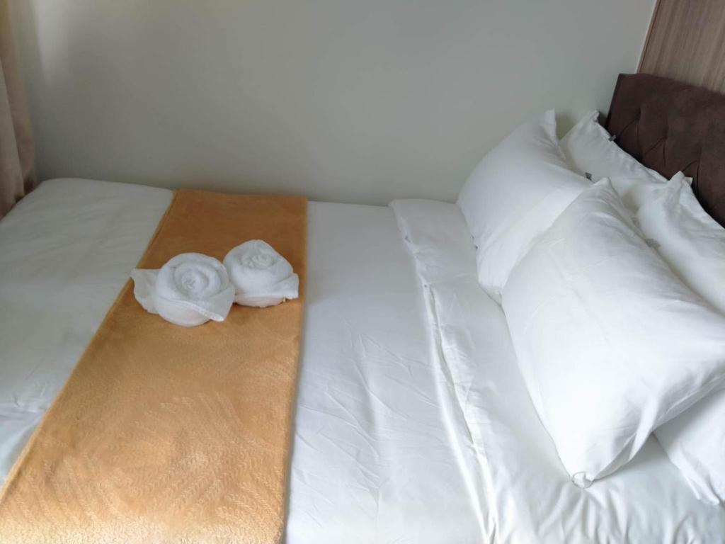 马尼拉SMDC Shore 2 Residences Tower2 Condo的一张白色的床,上面有两条白色毛巾