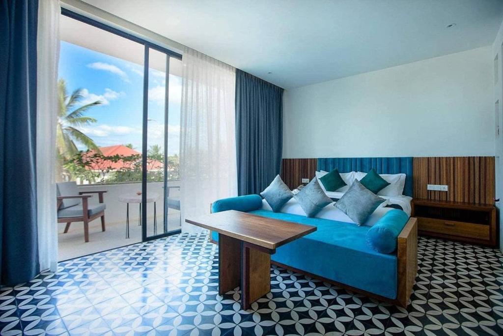 暹粒Tushita Villa, Pool & Gardens的客厅配有蓝色的沙发和桌子