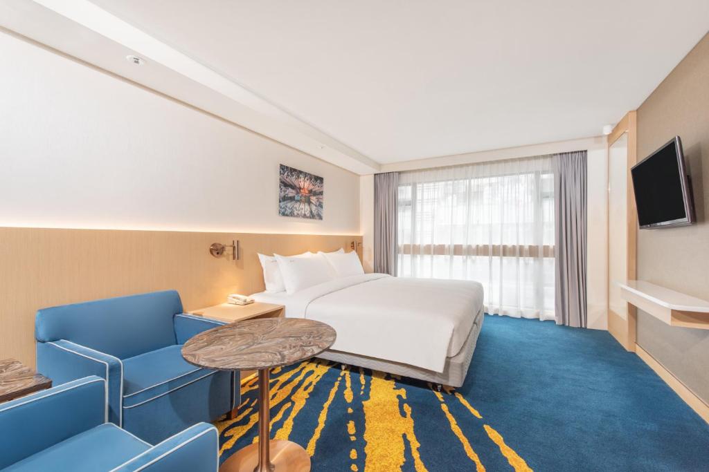 香港香港金域假日酒店的酒店客房带一张床、一张桌子和椅子