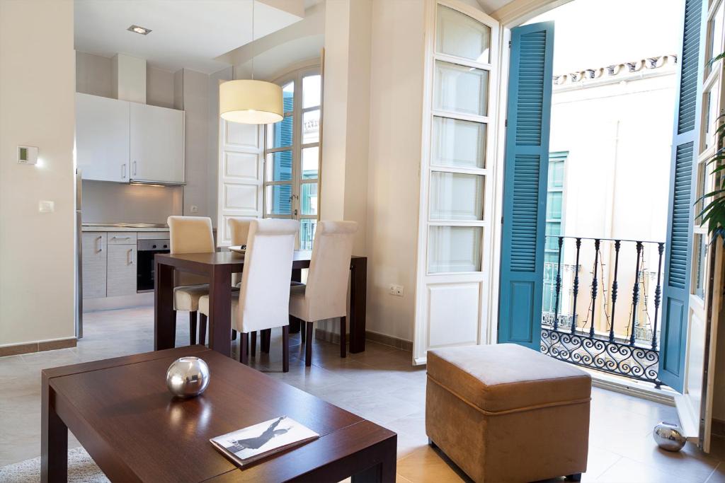 马拉加皮纳尔马拉加中心公寓酒店的厨房以及带桌椅的起居室。