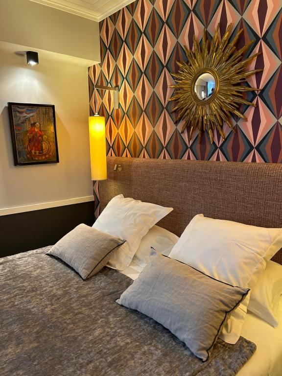 香槟沙隆Hôtel jardin Le Pasteur的一间卧室配有一张带两个枕头和镜子的床