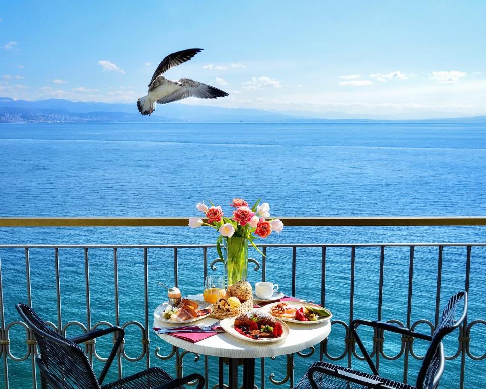 奥帕提亚萨沃伊酒店的一张桌子,上面放着食物,一只鸟飞过水面