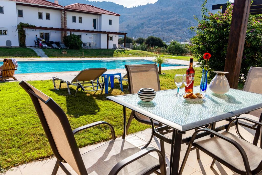 科林比亚Posidonia Luxury Villas Kolympia的一张桌子,上面放着一瓶葡萄酒和两杯酒