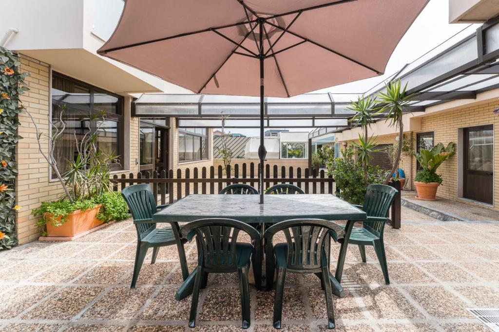 拉夫拉Angeiras Beach House - C3的庭院配有桌椅和遮阳伞。