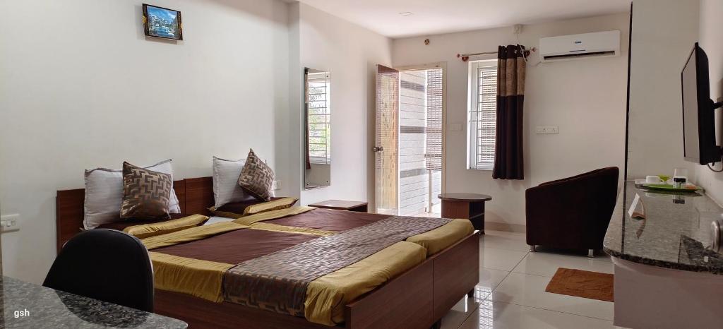 迈索尔Sugamya Corner Guesthouse的一间设有床铺的卧室,位于带窗户的房间内
