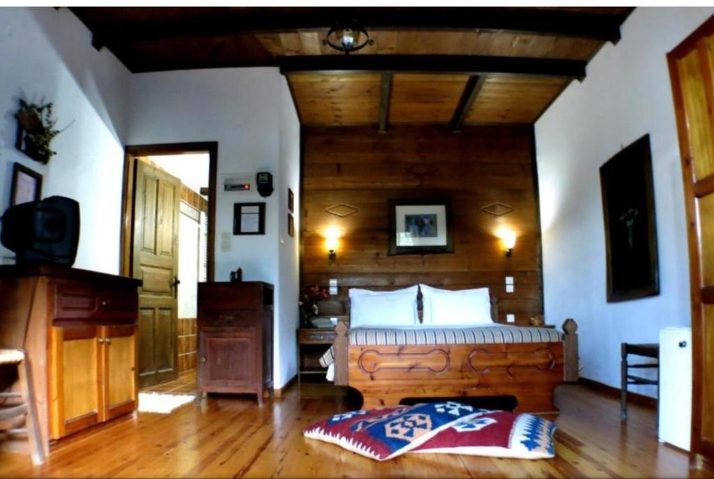 埃拉蒂特里卡隆塞诺娜斯布里兹酒店的一间卧室设有一张大床和木制天花板