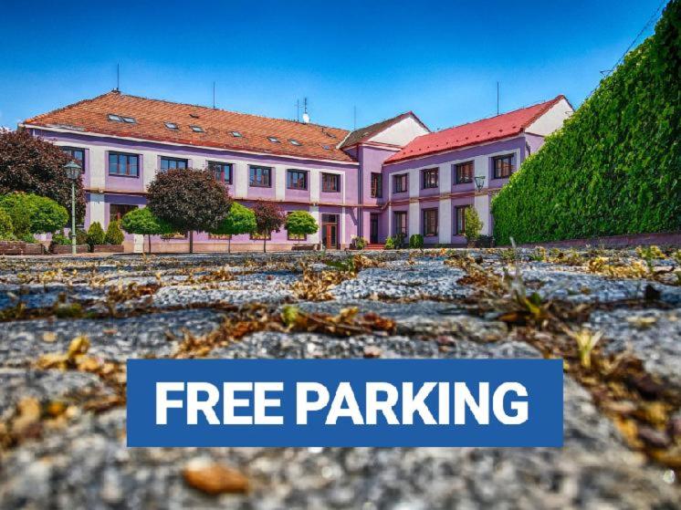 布尔诺优赫利公基酒店的一个大粉红色的房子,有字条免费停车场